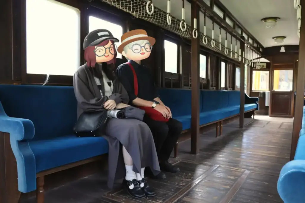 レトロな木造車両の座席に座る夫婦