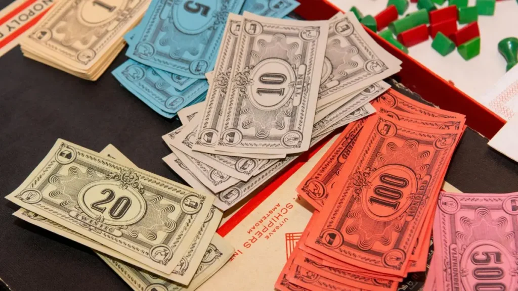 バラバラに散らばった紙幣のおもちゃ。通貨価値の下落やデフォルト（債務不履行）のリスクへの備え。