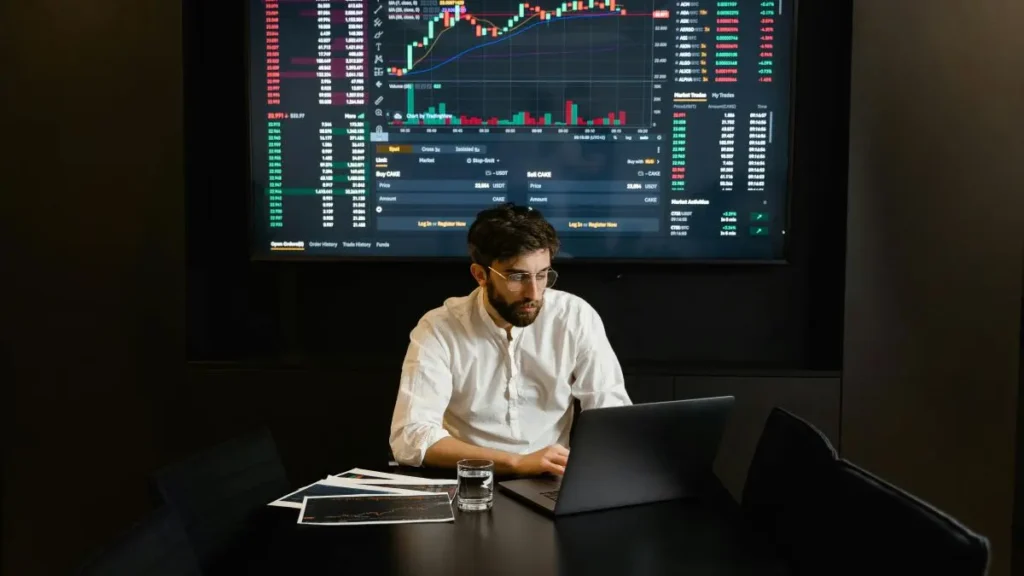 株価チャートの前で分析する投資家。S&P500や全世界株式（オルカン）の相関を考えるポートフォリオ構築のイメージ。