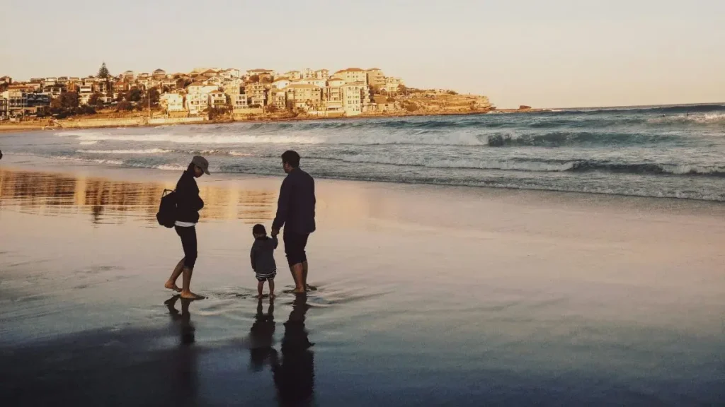 子育て世帯の家計の見える化｜海岸を歩く家族のイメージ