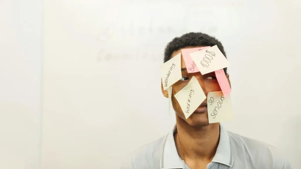 情報過多で市場の判断が歪む様子を付箋が貼られた男性で表現したイメージ