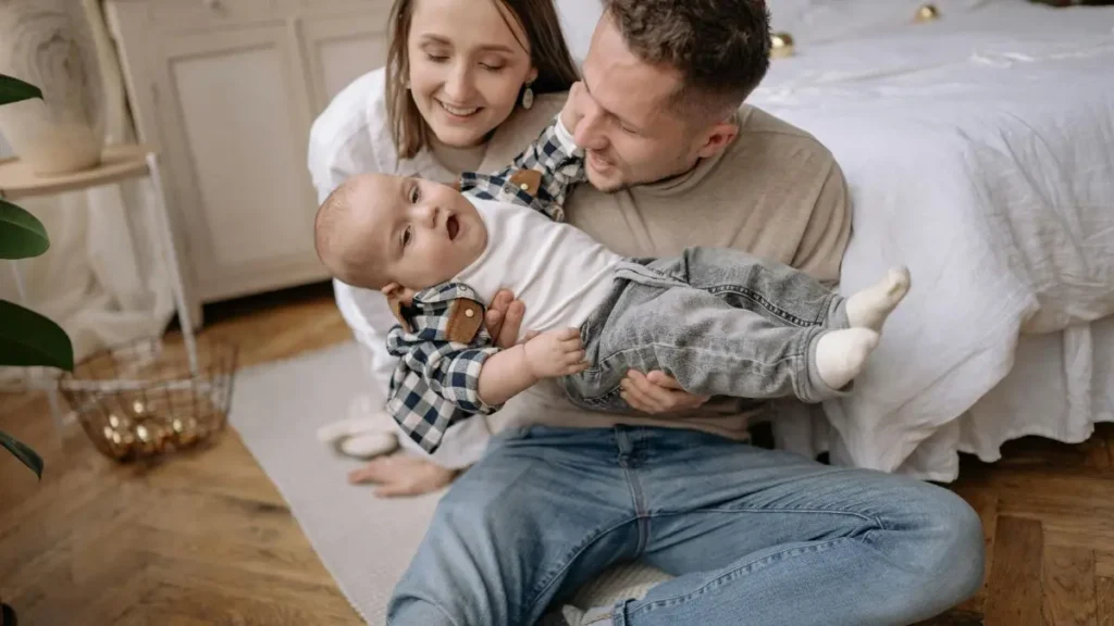 離乳食の汚れに悩むパパとママが、赤ちゃんを囲んで穏やかに過ごすイメージ写真。