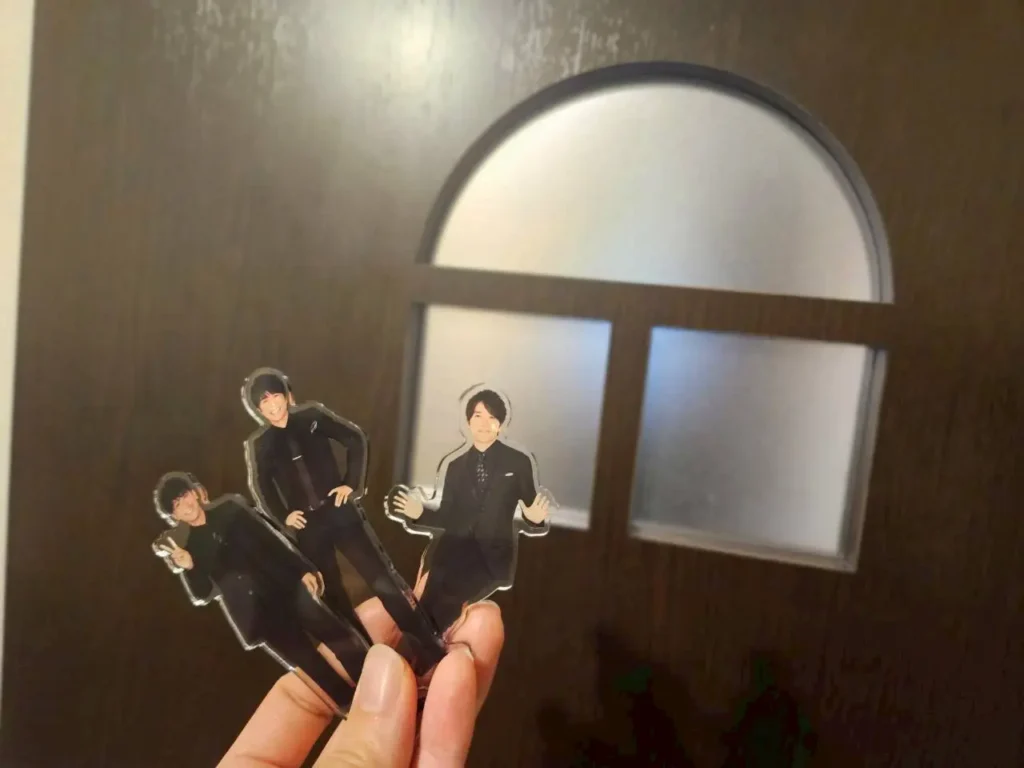 喫茶二十世紀の個室の扉の前で、20th Century（トニセン）のメンバー3人のアクリルスタンドを掲げて撮った記念写真。