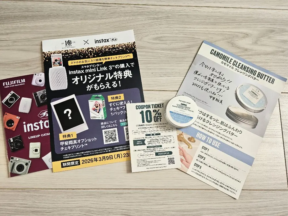 甲斐翔真10周年ライブの入場者特典セット。富士フイルムinstaxのカタログやチラシ、THE BODY SHOP（ザボディショップ）のクレンジングバターのサンプル、クーポン、直筆メッセージ入りフライヤーの全体像。